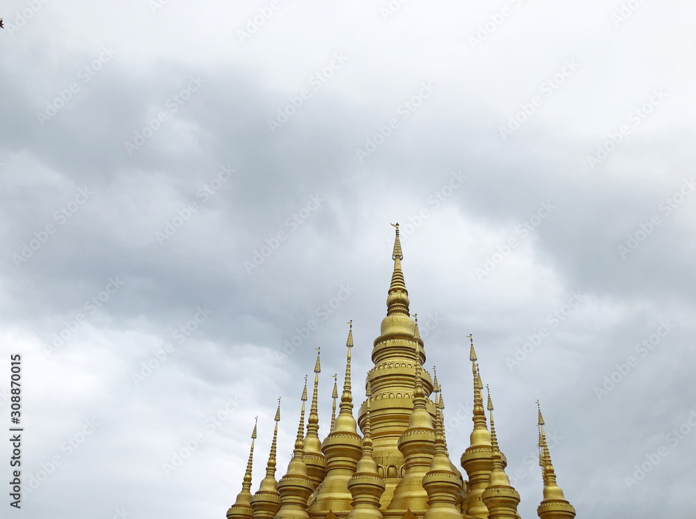 Fototapeta premium Golden pagoda in Buddhist temple in Xishuangbanna, Sipsongpanna, or Sibsongbanna in the south of Yunnan province, People's Republic of China.