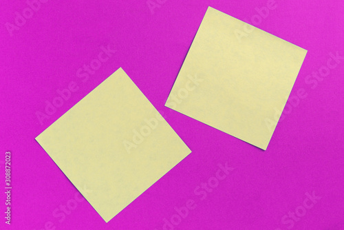 Two square sticker notes on a bright pink background close up