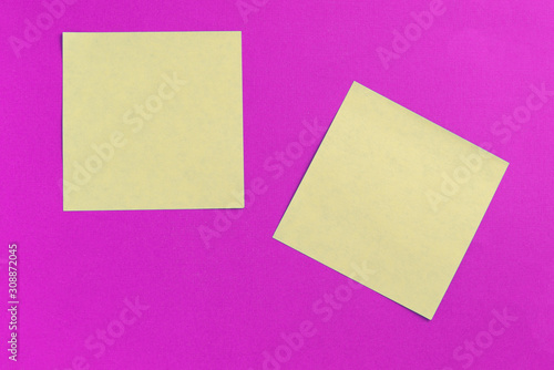 Two square sticker notes on a bright pink background close up