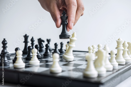 Business woman playing chess and thinking strategy about crash overthrow the opposite team and development analysis for win and successful