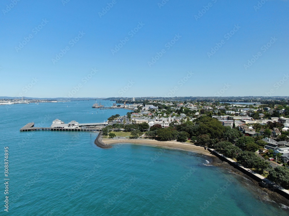 Devonport, Auckland / New Zealand - December 11, 2019: The Victorian Style Seaside Village of Devonport, with the skyline of Auckland’s landmarks and CBD in the background