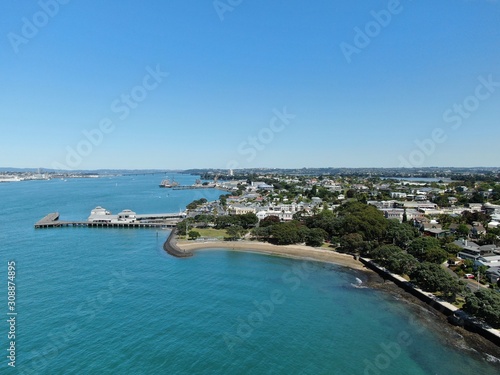 Devonport, Auckland / New Zealand - December 11, 2019: The Victorian Style Seaside Village of Devonport, with the skyline of Auckland’s landmarks and CBD in the background © Julius