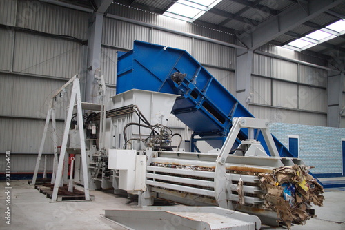 Horizontal hydraulic press for recyclable materials against the wall of a building