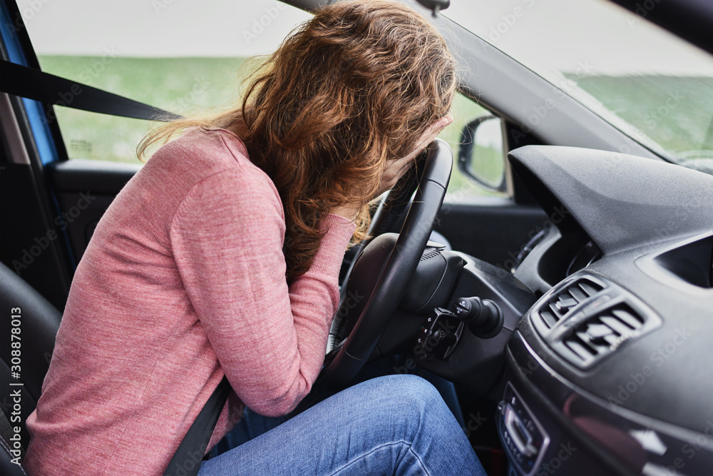 Stressed woman covering face with hands in the car. Driver panic concept