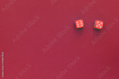 Red dice on a dark red background. Gambling concept, top view, copy space.