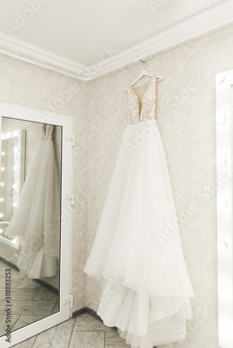 wedding dress hanging on the mirror, bride's morning