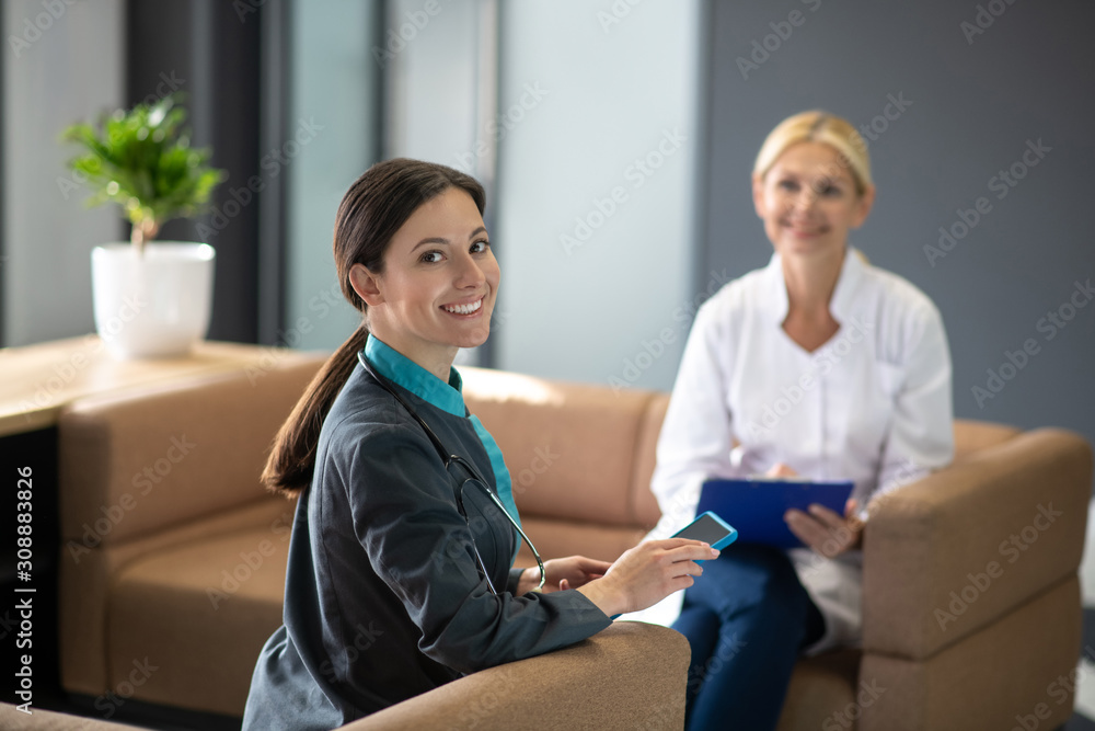 Obraz premium Dark-haired young female intern feeling good at work