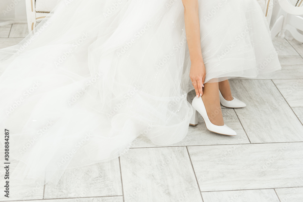 The details of the wedding day. Bride wears wedding shoes