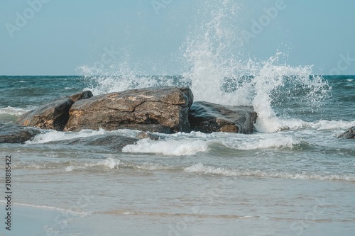 Sea wave and Splashes hits the stone on the Hua Hin beach, Prachuap Khiri Khan, Thailand. Pastel tone.