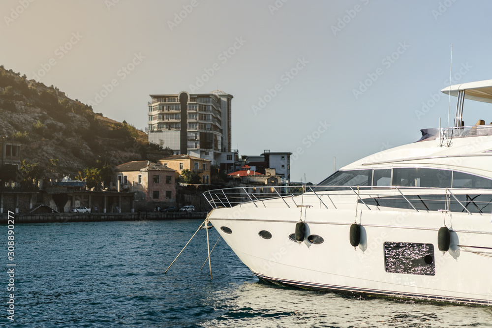 Fototapeta premium White luxury yacht anchored against the background of the coast. The bow of the boat, Balaklava, Crimea.