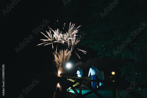 Golden big shiny fireworks with bokeh lights in the night sky. Glowing firework show. New Year or wedding photo