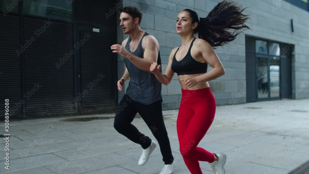 Sport couple running outdoor in slow motion. Young man and woman training run Sport couple running outdoor in slow motion. Young man and woman training run