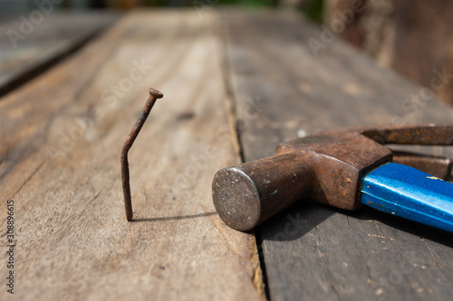 Fotografija Hammer and bent nail on wooden floor