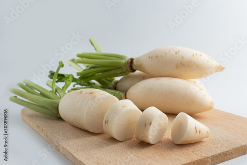 White radish on a wooden cutting board, white background