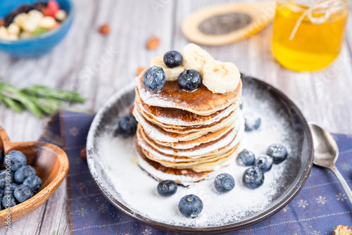 delicious Breakfast pancakes on a plate with blueberries and honey