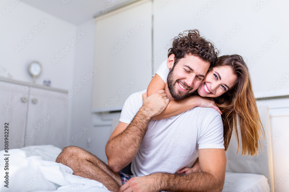 Beautiful young couple at home. Hugging, kissing and enjoying spending time together. Passionate beautiful couple in bedroom enjoying foreplay Beautiful young couple at home. Hugging, kissing and enjoying spending time together. Passionate beautiful couple in bedroom enjoying foreplay