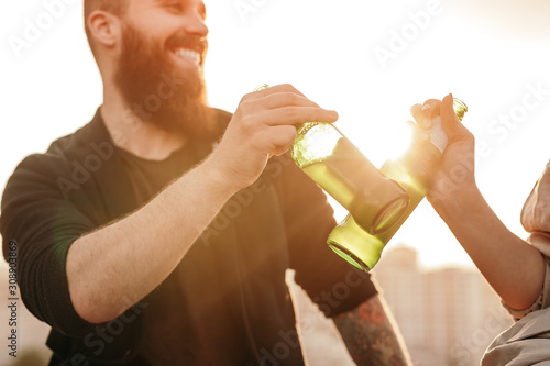 Fotografia Crop couple drinking beer during date