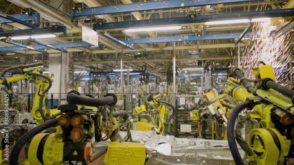 Automated robots at work inside an automobile manufacturing plant Automated robots at work inside an automobile manufacturing plant