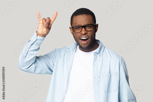 Funny crazy african american young man showing horns gesture.