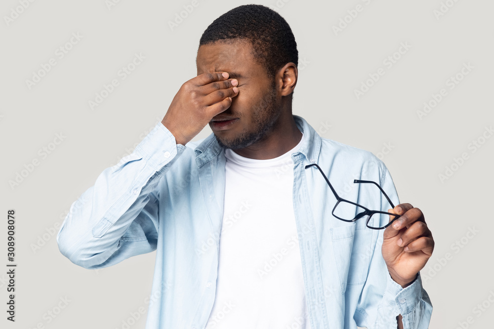 Exhausted unhealthy young african american man rubbing irritated eyes. Exhausted unhealthy young african american man rubbing irritated eyes.