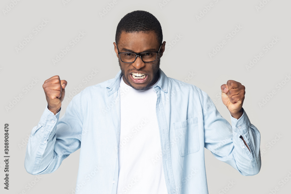 Irritated angry african american guy clenching both hands in fists. Irritated angry african american guy clenching both hands in fists.