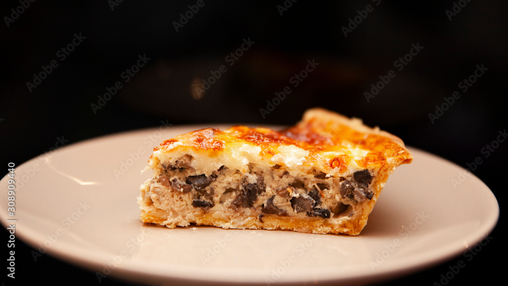 A piece of pie with meat and mushrooms lies on a plate A piece of pie with meat and mushrooms lies on a plate