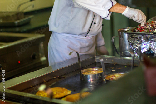 The chef bakes omelettes in the open kitchen of the hotel.