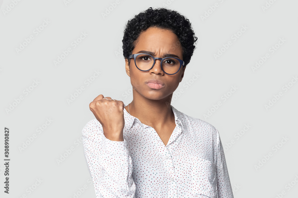 Angry african american serious girl clenching fist, demonstrating power. Angry african american serious girl clenching fist, demonstrating power.