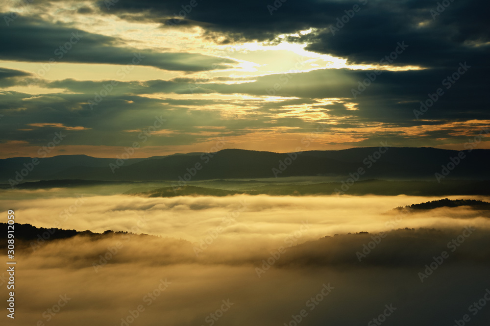 Magic sunrise with clouds and fog in the mountains.