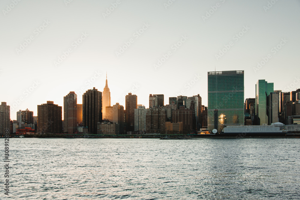 New York Manhattan skyline with Empire State illuminated by sun