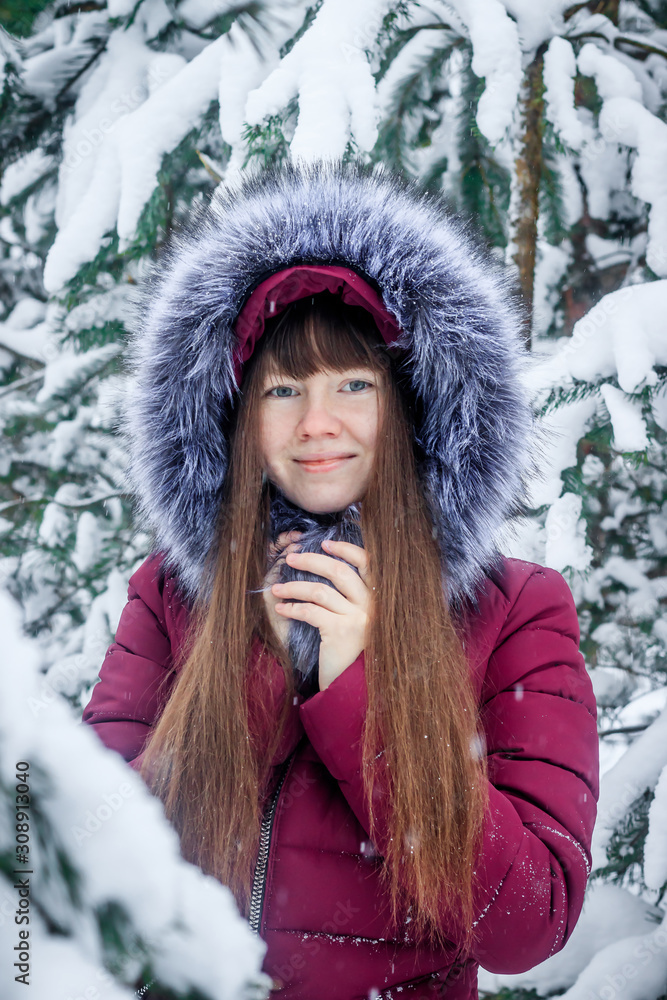 Girl in a coat on the background of snow-covered trees . . Girl winter on stroll. Winter fairy tale. Christmas trees in the snow Girl in a coat on the background of snow-covered trees . . Girl winter on stroll. Winter fairy tale. Christmas trees in the snow
