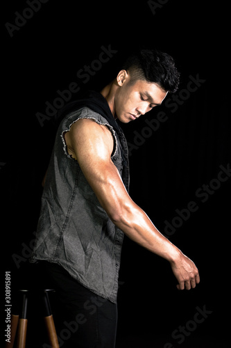 Muscle bodybuilder asia men posing muscle front on the black background. Body gym big chest and shoulder. Fashion style
