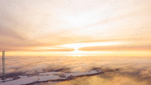 Aerial view White clouds in blue sky. Top view. View from drone. Aerial bird's eye view. Aerial top view cloudscape. Texture of clouds. View from above. Sunrise or sunset over clouds