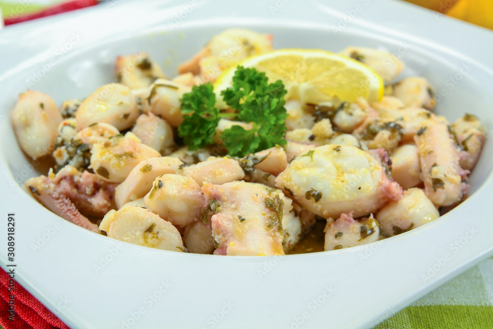 Octopus pieces cooked with garlic and parsley on a plate Octopus pieces cooked with garlic and parsley on a plate