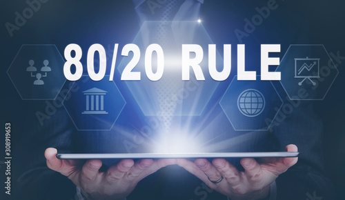 Businessman holding a computer tablet display projecting a 80 / 20 Rule concept.