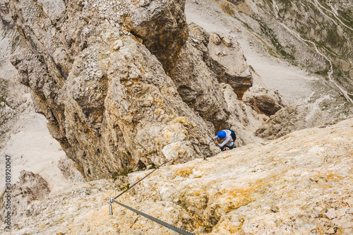 Wspinaczka po via ferrata - włoskie Alpy. Turystyka górska w Dolomitach.