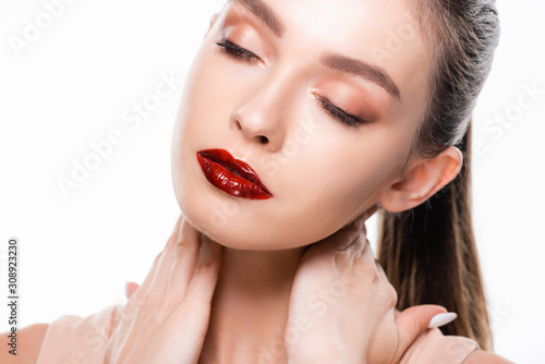 beautiful young woman with makeup touching neck with closed eyes isolated on white