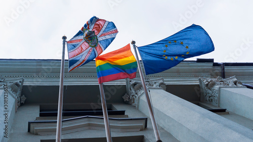 Rainbow flag or pride flag, union jack or Great Britain flag and United Europe flag on the facade of the building. photo