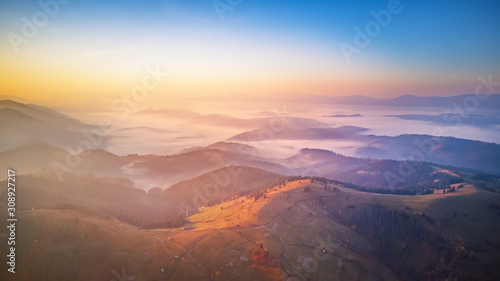 Aerial panorama of autumn mountains. Sunrise over foggy valley