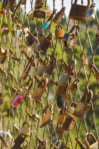 Old rusted love locks on a grid fence