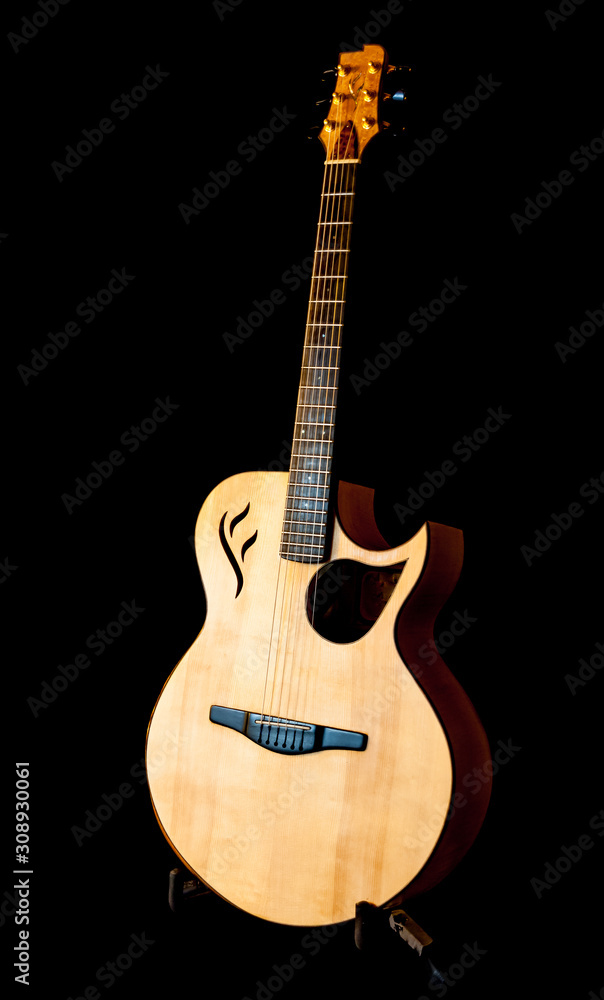 Obraz premium A portrait of a hand made guitar on a black background.