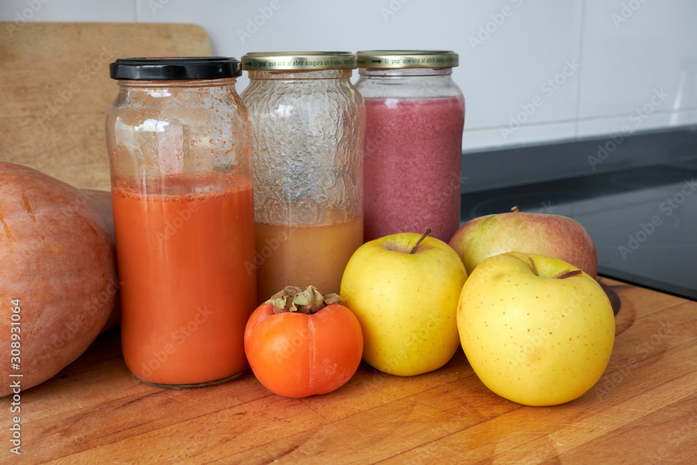 homemade carrot, pear and pomegranate juice in jars homemade carrot, pear and pomegranate juice in jars