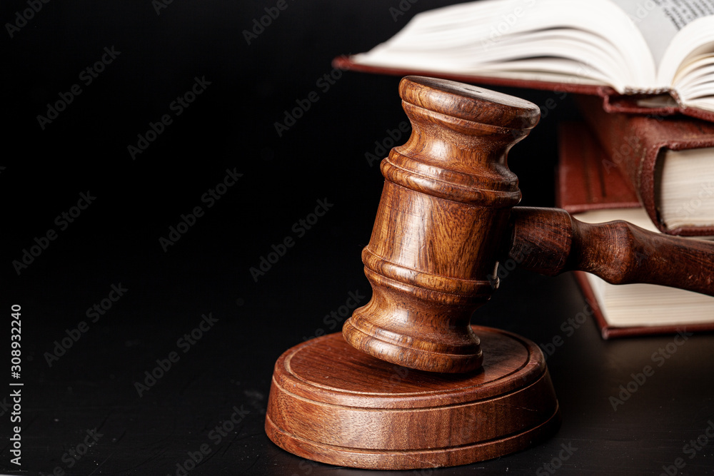 Wooden gavel and juridical books close up