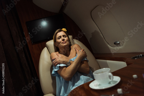 selective focus of terrified woman sitting in private plane photo