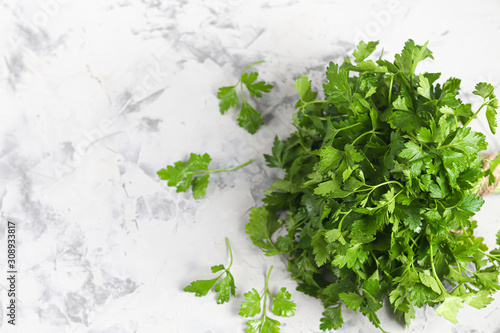 Parsley lies on a gray, stone background. Healthy, vitamin food.