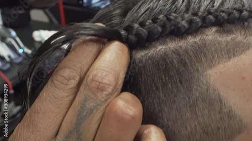 Braiding man's hair at barbershop photo