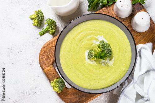 Broccoli cream soup in the bowl on white table.