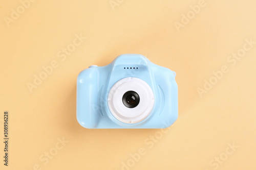 Light blue toy camera on beige background, top view