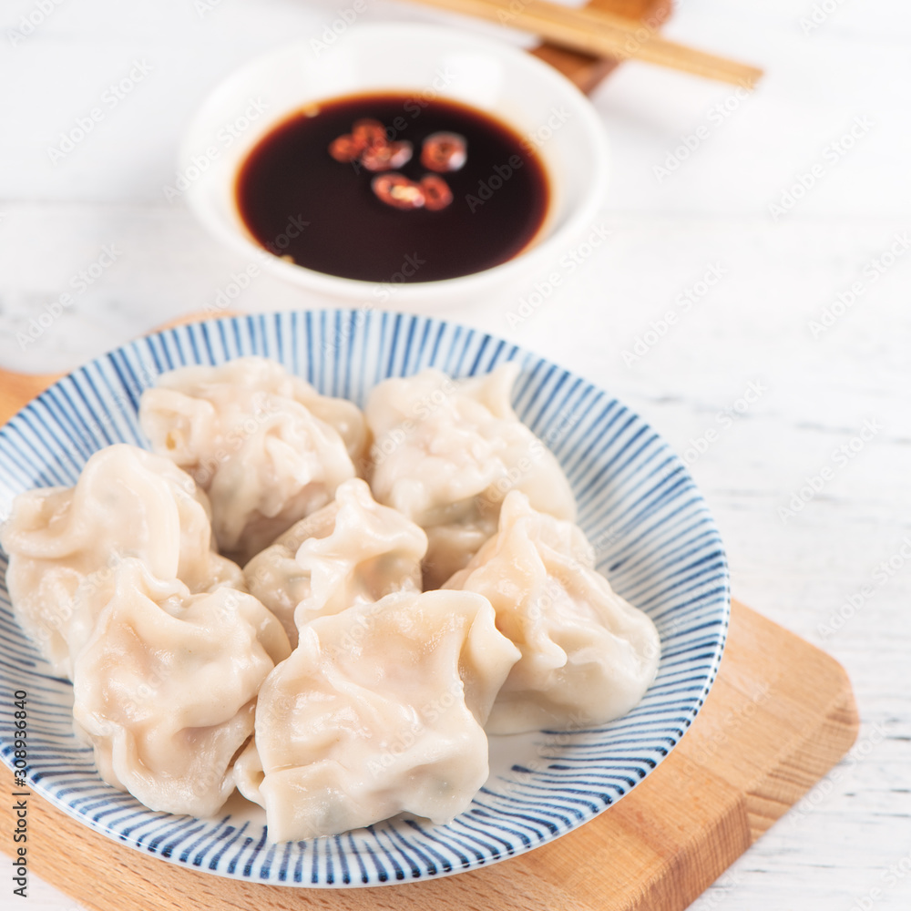 Fresh, delicious boiled pork gyoza dumplings, jiaozi on white background with soy sauce and chopsticks, close up, lifestyle. Homemade design concept. Fresh, delicious boiled pork gyoza dumplings, jiaozi on white background with soy sauce and chopsticks, close up, lifestyle. Homemade design concept.