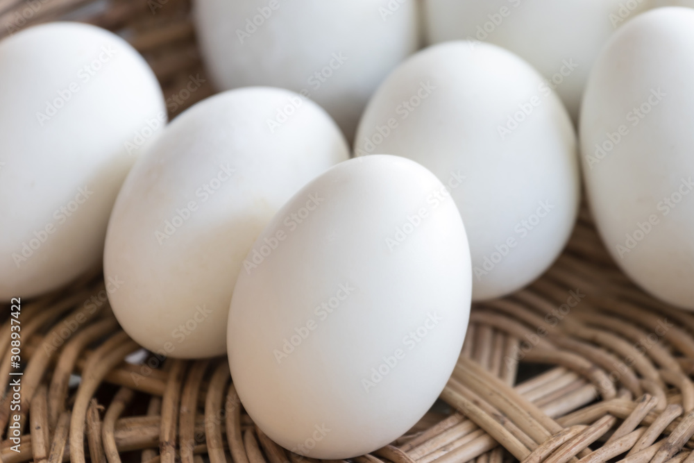 Many white duck eggs placed in a basket Many white duck eggs placed in a basket